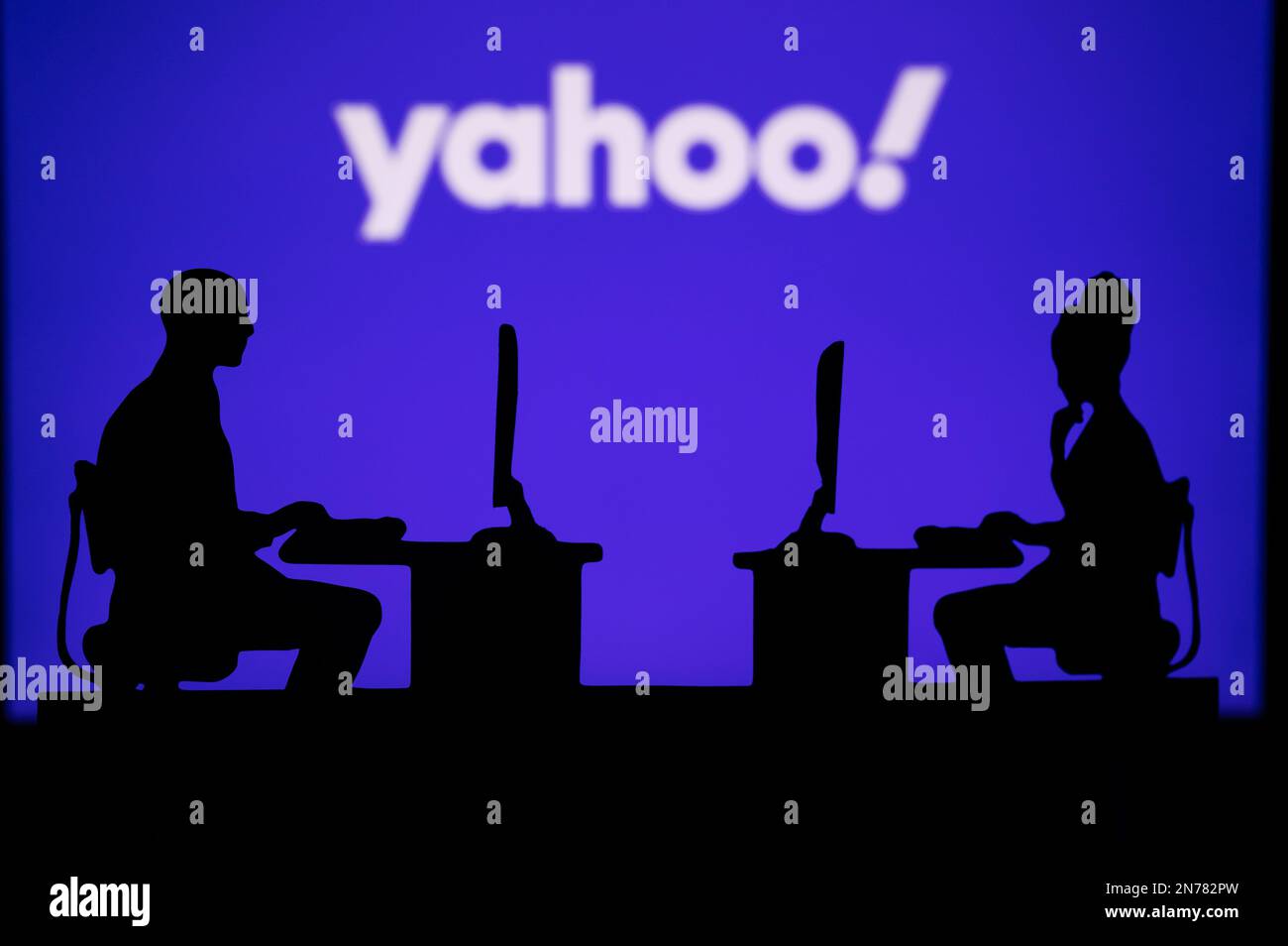 INDIA, NUOVA DELHI. 30 GENNAIO 2023: Yahoo. Innovare il futuro: La silhouette di due sviluppatori di software e il logo aziendale sullo sfondo Foto Stock