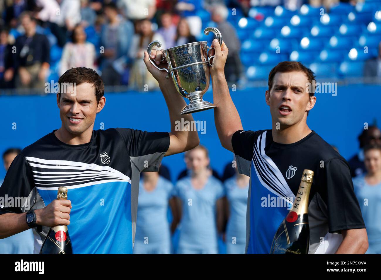 Bob Bryan, left, and Mike Bryan of U.S. hold up the trophy after their win against Alexander Peya of Austria and Bruno Soares of Brazil at the end of their Queen's Club grass court championships double final tennis match in London, Sunday, June 16, 2013. (AP Photo/Sang Tan) Foto Stock