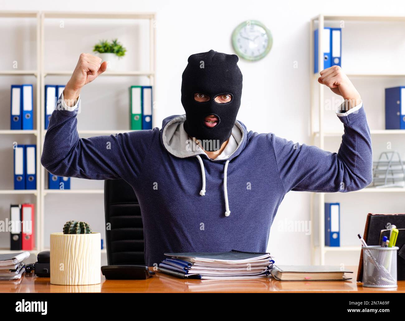 Il ladro maschio in passamontagna in ufficio Foto stock - Alamy