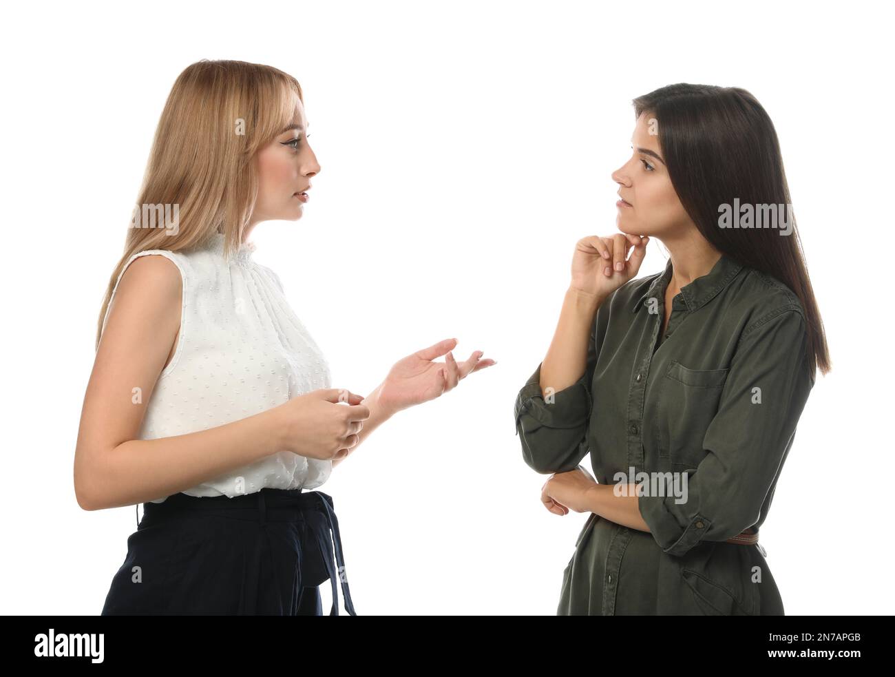 Giovani donne in abiti casual che parlano su sfondo bianco Foto Stock