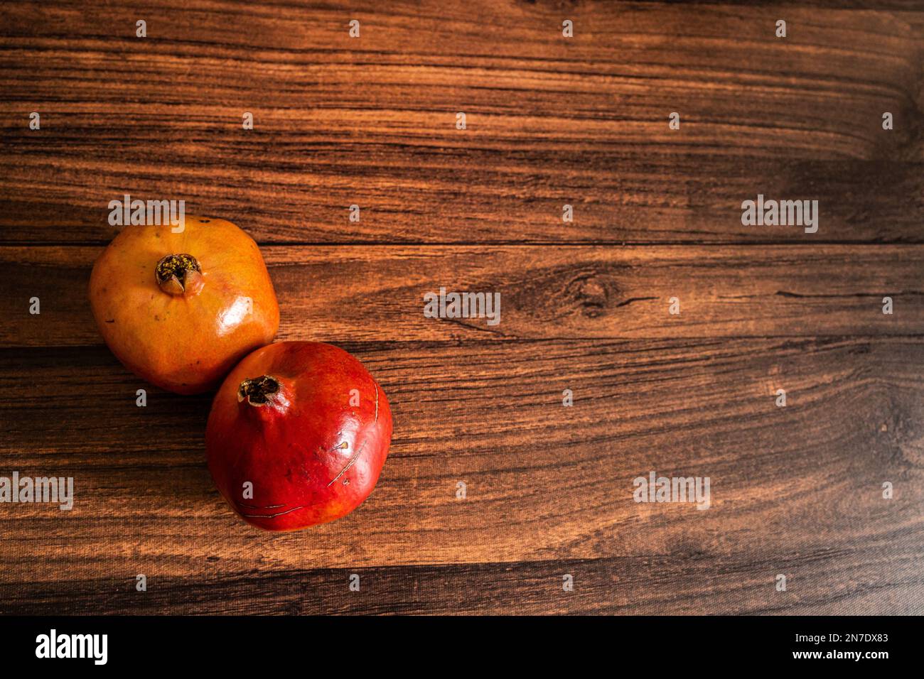 Vista dall'alto di melograni maturi biologici tenuti su un tavolo di legno con spazio copia Foto Stock