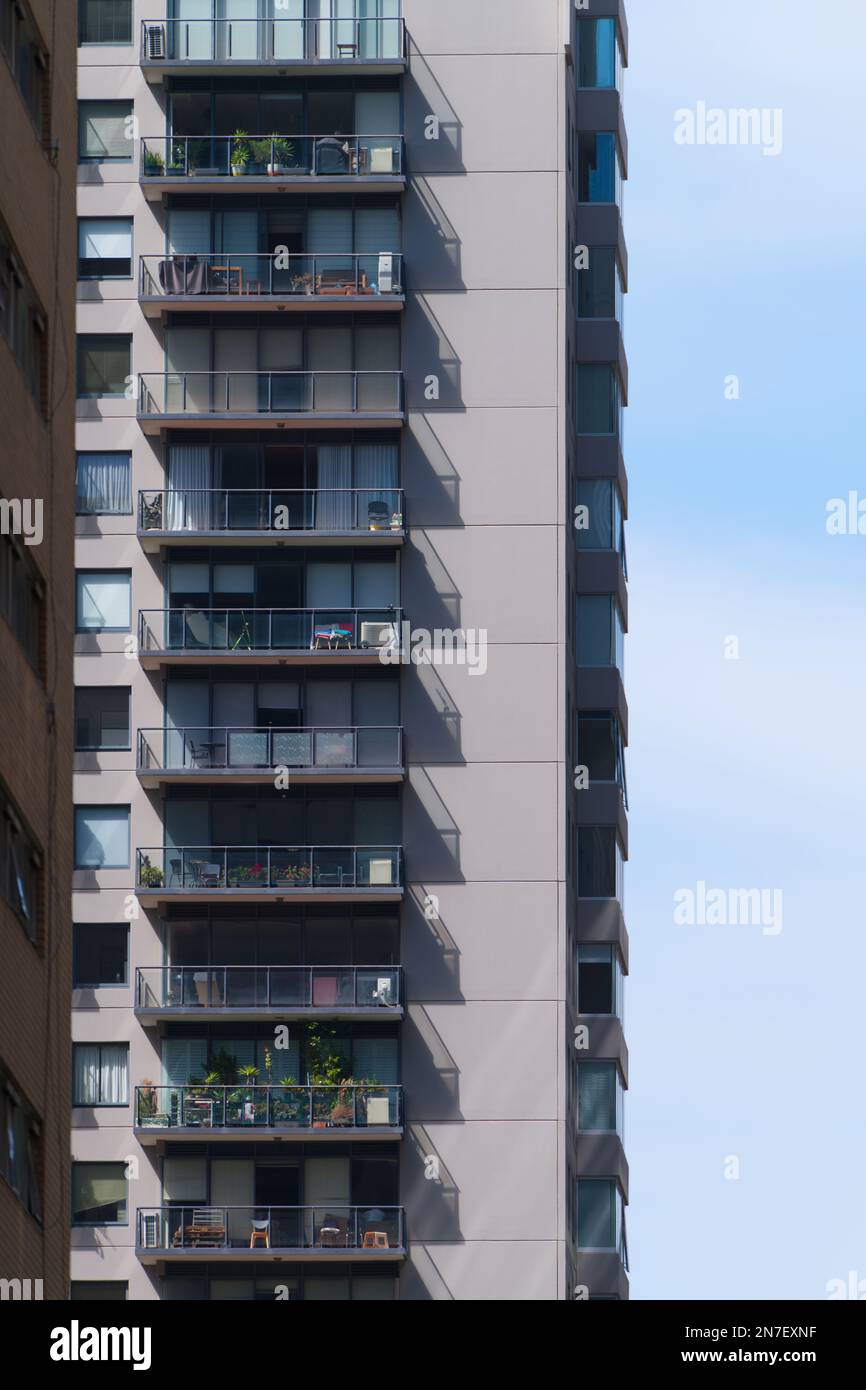 Stile di vita degli appartamenti a Melbourne, Australia, che mostrano l'esterno dell'edificio, balconi e finestre di vetro con un cielo azzurro tenue. Foto Stock