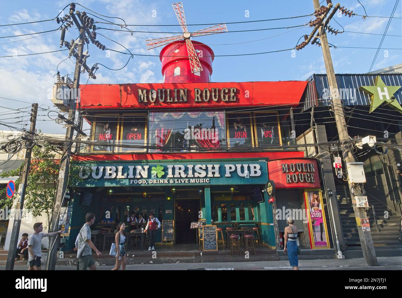 Un edificio in Bangla Rd., Patong, Phuket, Thailandia, con un punto di riferimento, Mulino a vento Faux sul tetto, ospita il Moulin Rouge club e il Dublin Irish Pub Foto Stock