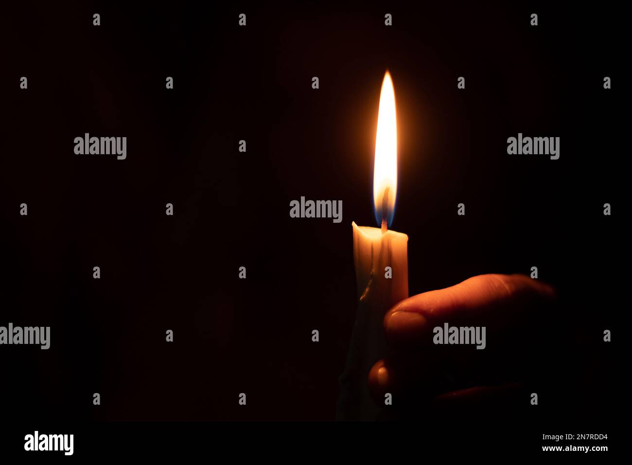 candela fiamma illumina una mano femmina in una stanza Foto Stock