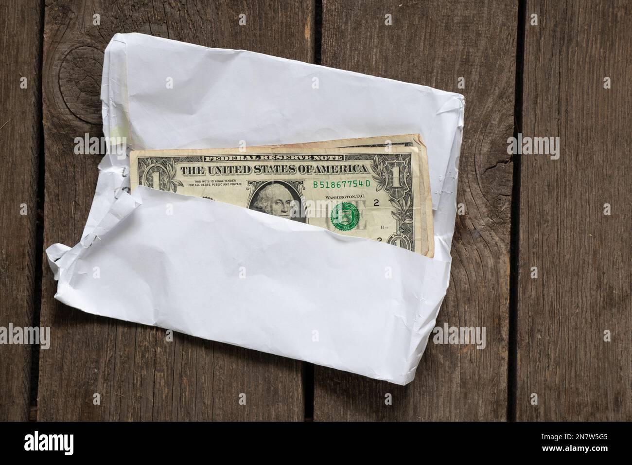 dollari americani in una busta bianca su un vecchio tavolo di legno primo  piano Foto stock - Alamy