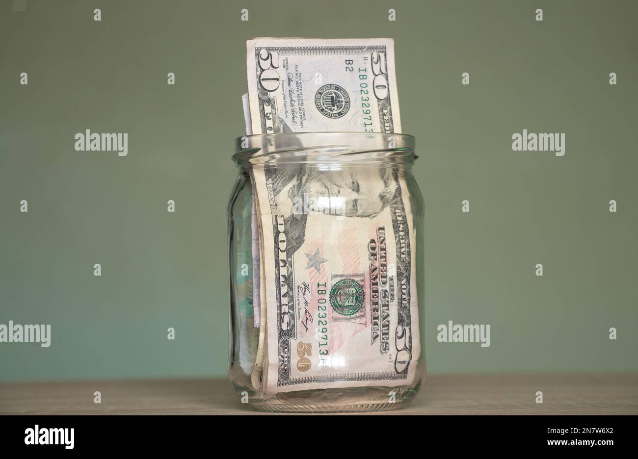 50 dollari si trovano in un vaso di vetro sul tavolo, tema finanziario Foto Stock