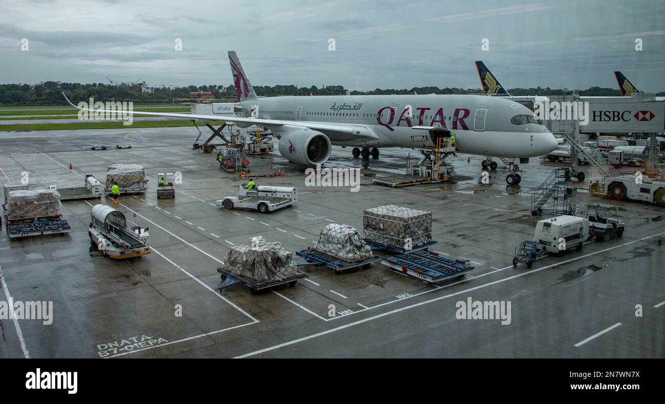 Aereo del Qatar sulla pista durante il giorno delle piogge all'Aeroporto di Changi. Changi è stato classificato come il miglior aeroporto al mondo per l'ottavo anno consecutivo nel 2020. Foto Stock