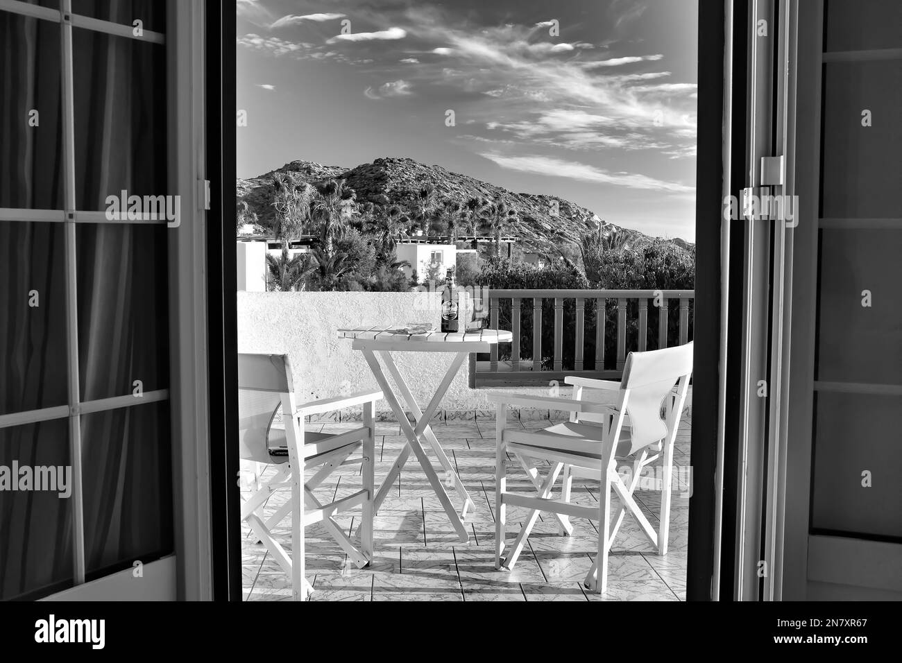 IOS, Grecia - 2 giugno 2021 : Vista del balcone di una villa che si affaccia sulla spiaggia di Mylopotas in Grecia iOS in bianco e nero Foto Stock