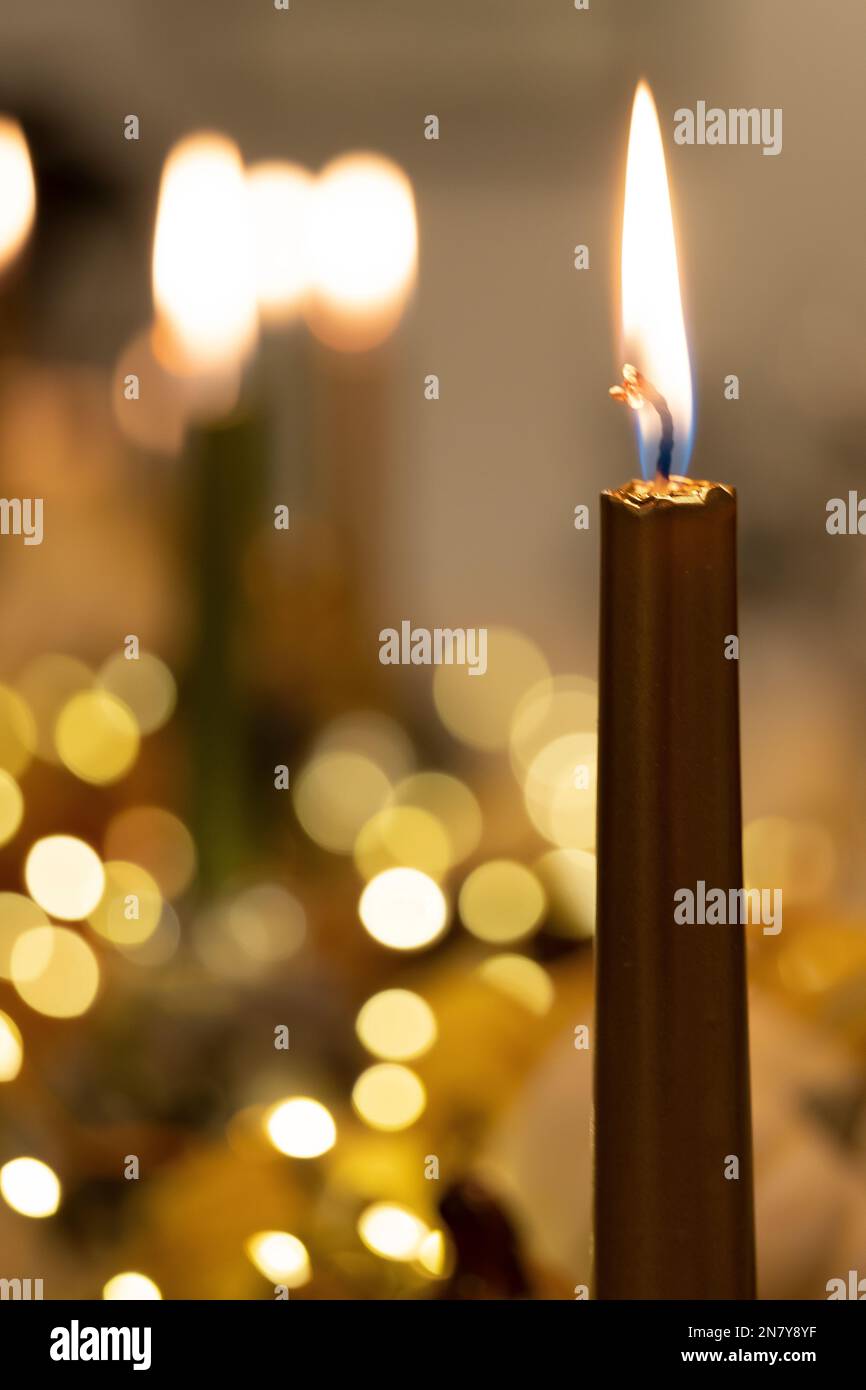 Uno scatto verticale di una candela illuminata con luci bokeh sullo sfondo sfocato per la cena del Ringraziamento Foto Stock