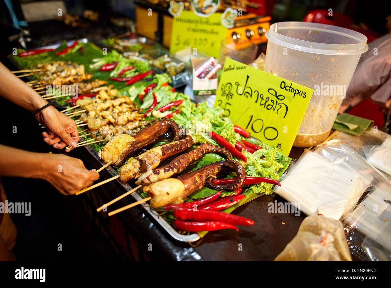 Street food di polpo fritto e piccante tailandese al mercato notturno al Capodanno cinese a Bangkok Chinatown in Thailandia Foto Stock