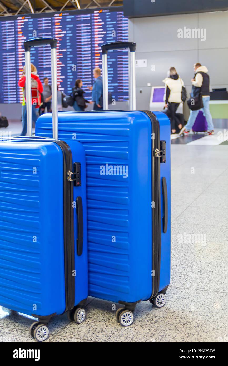 Travel Fashion. Ripresa ravvicinata di due valigie di plastica in piedi all'aeroporto, eleganti borse per bagagli in attesa nella sala terminal, banner per i viaggi aerei Foto Stock