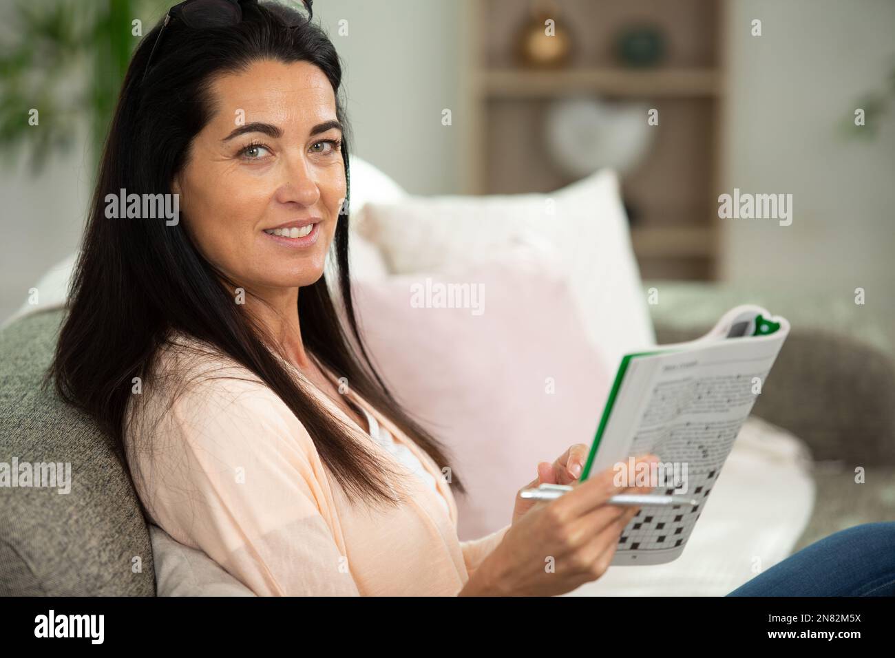 donna premurosa che fa un puzzle crossword criptico Foto Stock