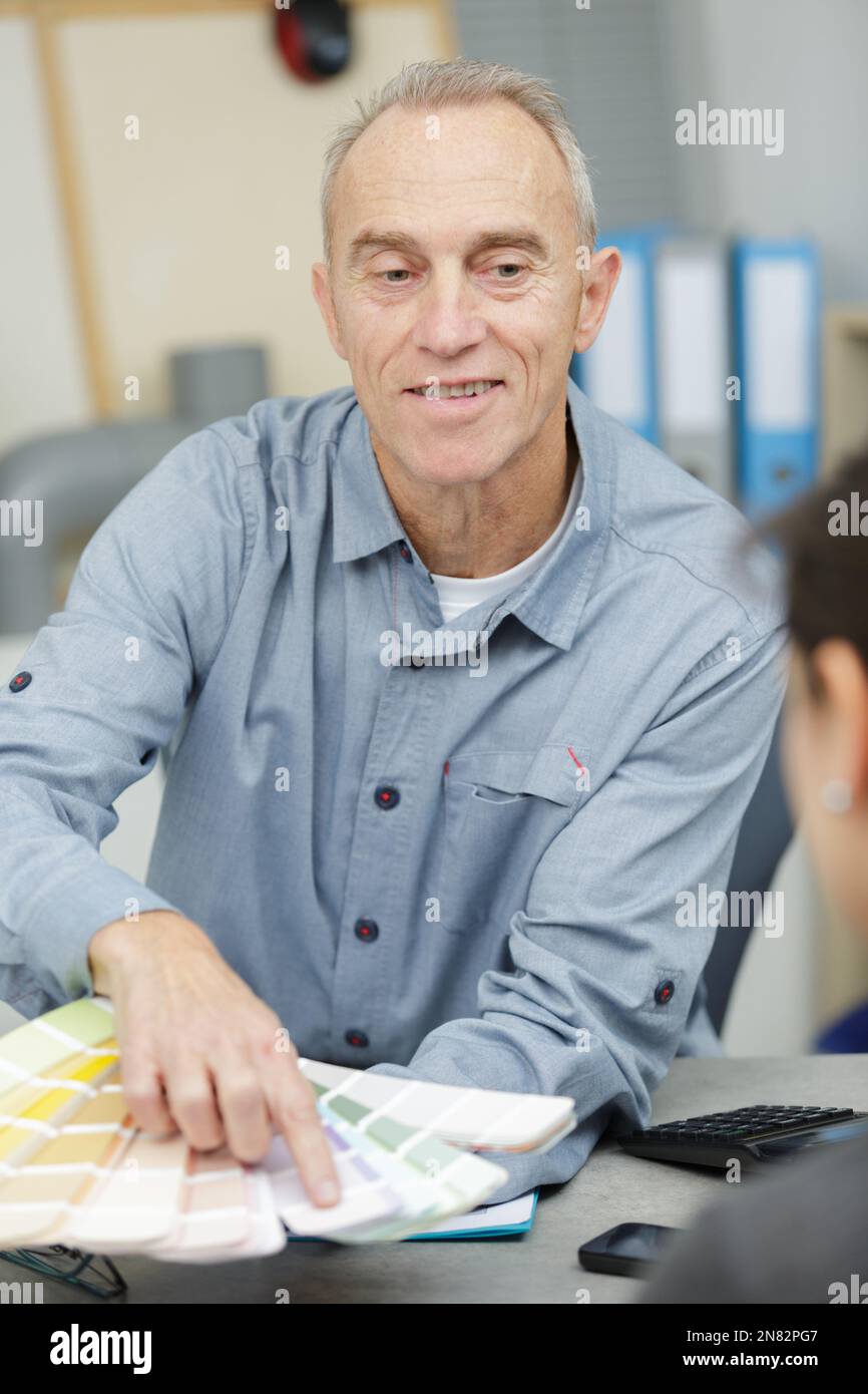 un lavoratore maturo che tiene grafici a colori Foto Stock