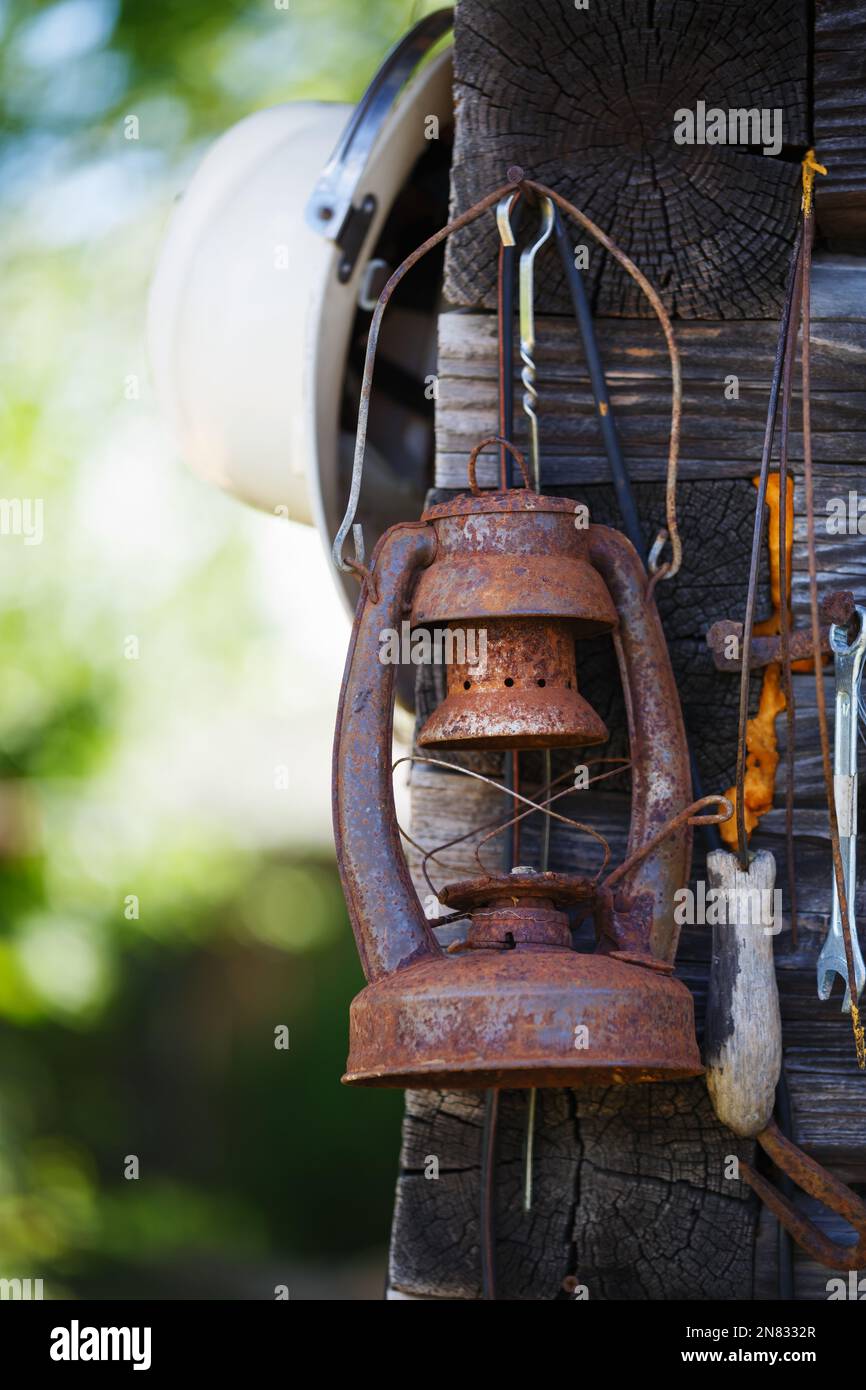 Vecchia lampada arrugginita kerosene pende all'angolo di una casa all'aperto. Foto Stock