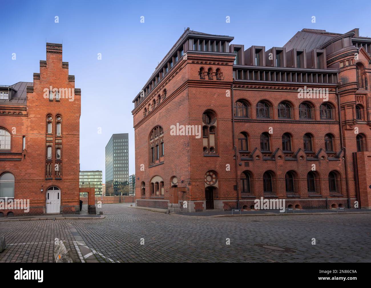 Edifici in mattoni nel quartiere dei magazzini di Speicherstadt con edifici moderni di Dovenfleet sullo sfondo - Amburgo, Germania Foto Stock