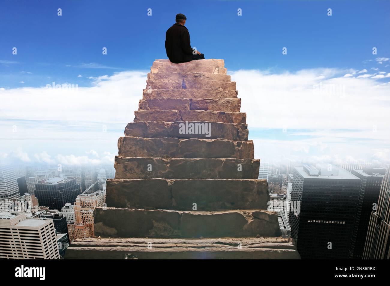 Un uomo siede sul gradino superiore di una scala in pietra che sale al cielo. L'uomo guarda giù alla città di New York. Foto Stock