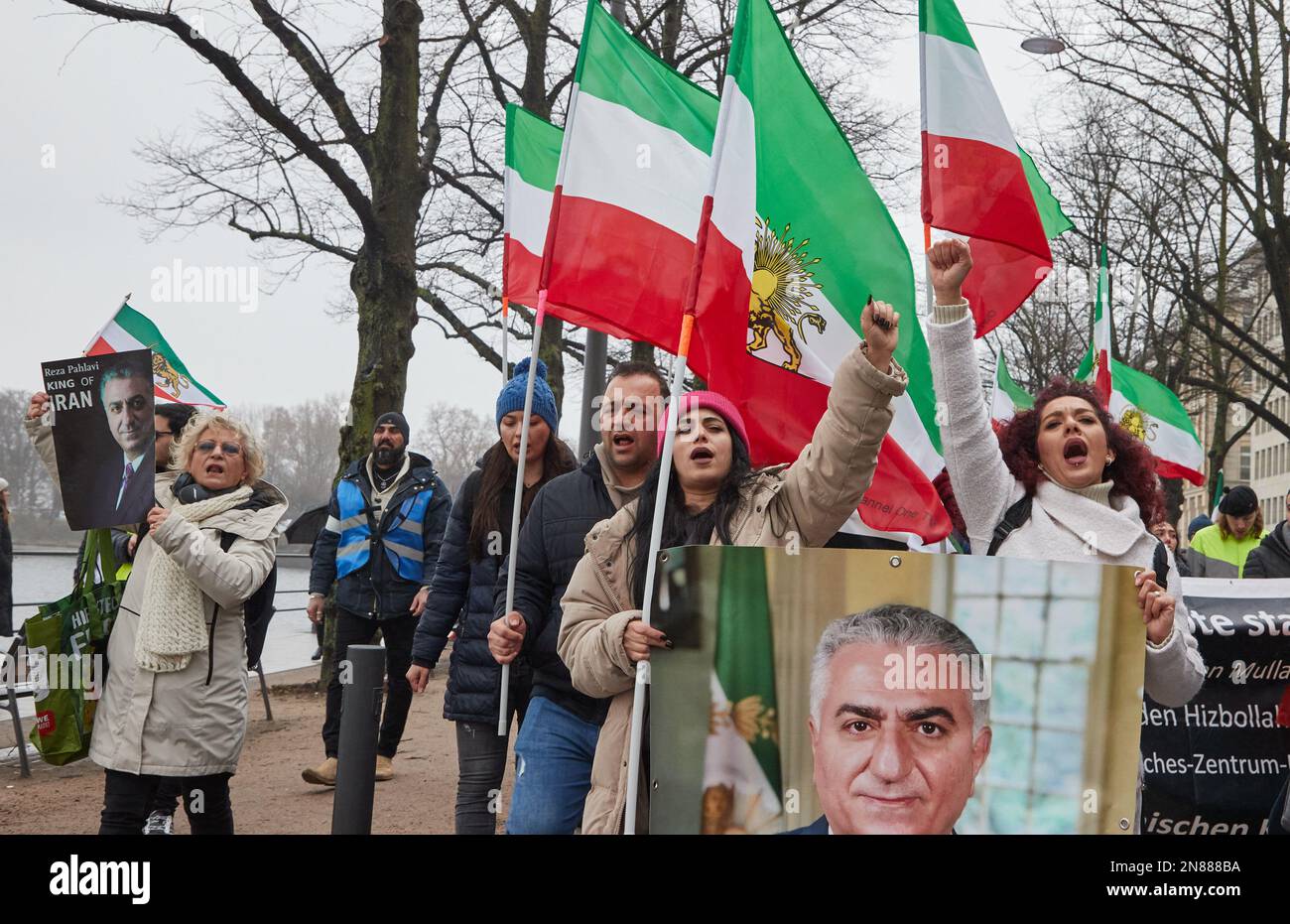 Amburgo, Germania. 11th Feb, 2023. I partecipanti a una manifestazione contro il regime iraniano detengono bandiere iraniane e foto dello scià persiano Mohammad Reza Pahlavi, rovesciato nel 1979, sul Ballindamm. L'Unione iraniana aveva chiesto la manifestazione. L'appello è stato rivolto dall'Unione iraniana. Sotto il motto "sostegno e solidarietà al popolo iraniano - protesta contro il regime iraniano”, i partecipanti hanno marciato da Mönckebergstraße al Rathausmarkt. Credit: Georg Wendt/dpa/Alamy Live News Foto Stock