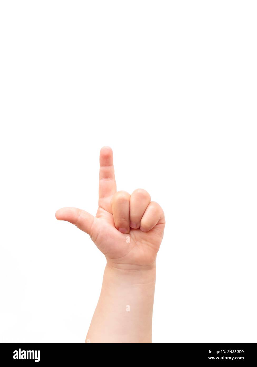 La mano del bambino su sfondo bianco. Il bambino punta qualcosa con il dito indice. Piano di giacitura, vista dall'alto, copyspace. Foto Stock