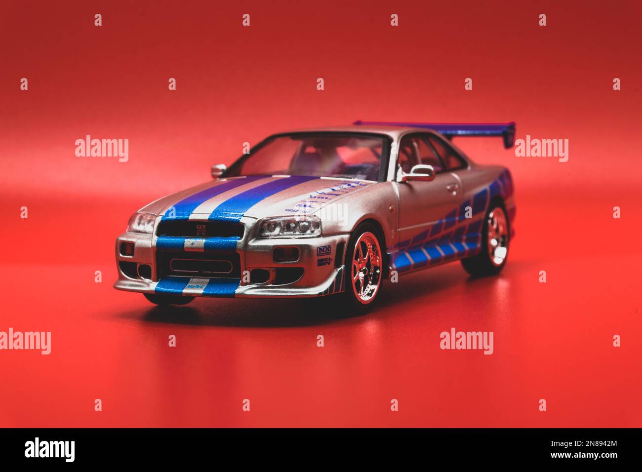 Auto FAST&Furious Nissan Skyline GT-R R34 1:43, vista frontale, sfondo rosso Foto Stock