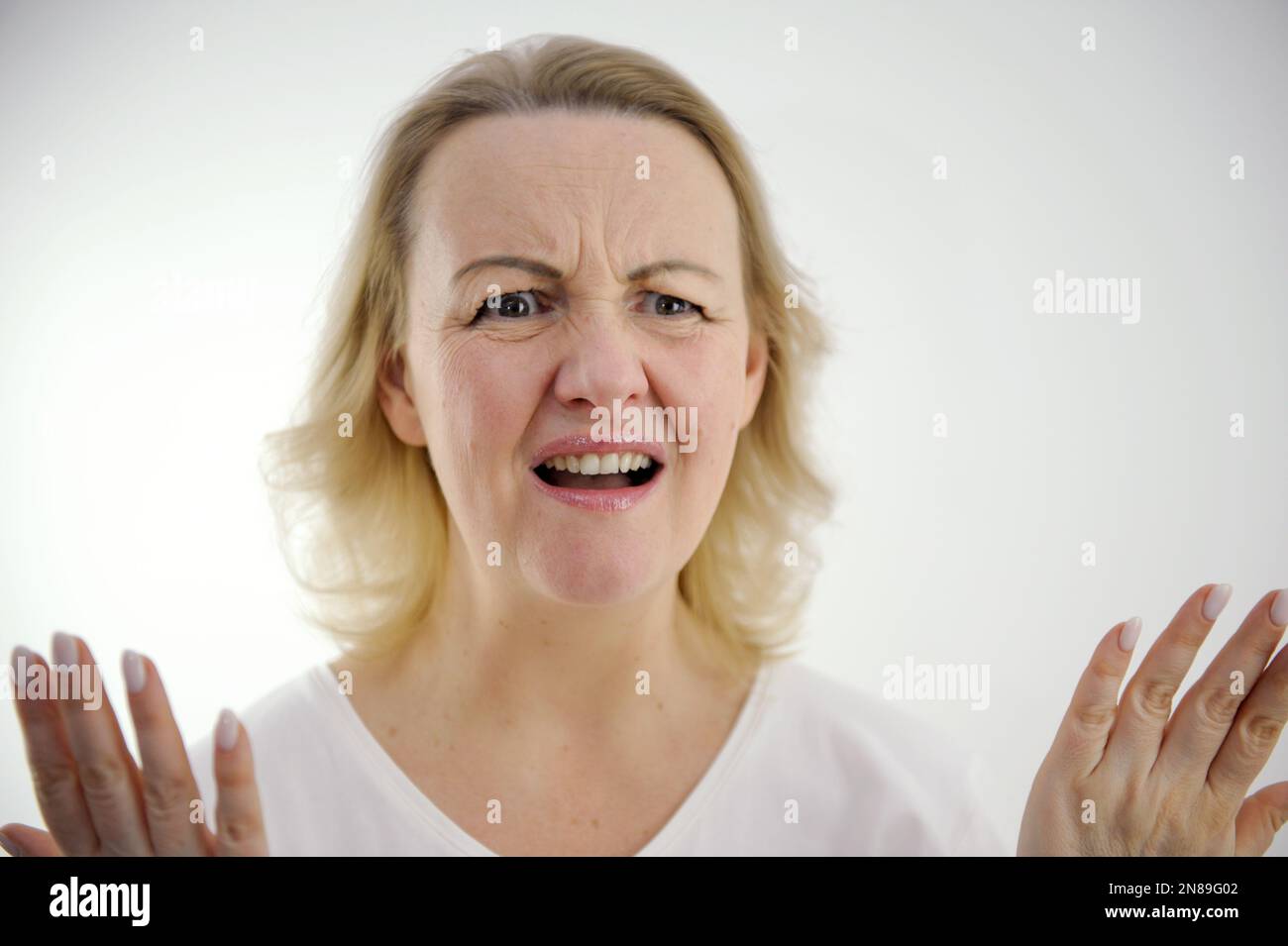 Sfondo bianco disgruntled donna sollevato mani in su mostrando che realmente seriamente la bocca è aperta stampa fronte sopracciglia solcata e rabbia di frustrazione disperazione sulla faccia ingiustificata speranze cattivo prodotto Foto Stock