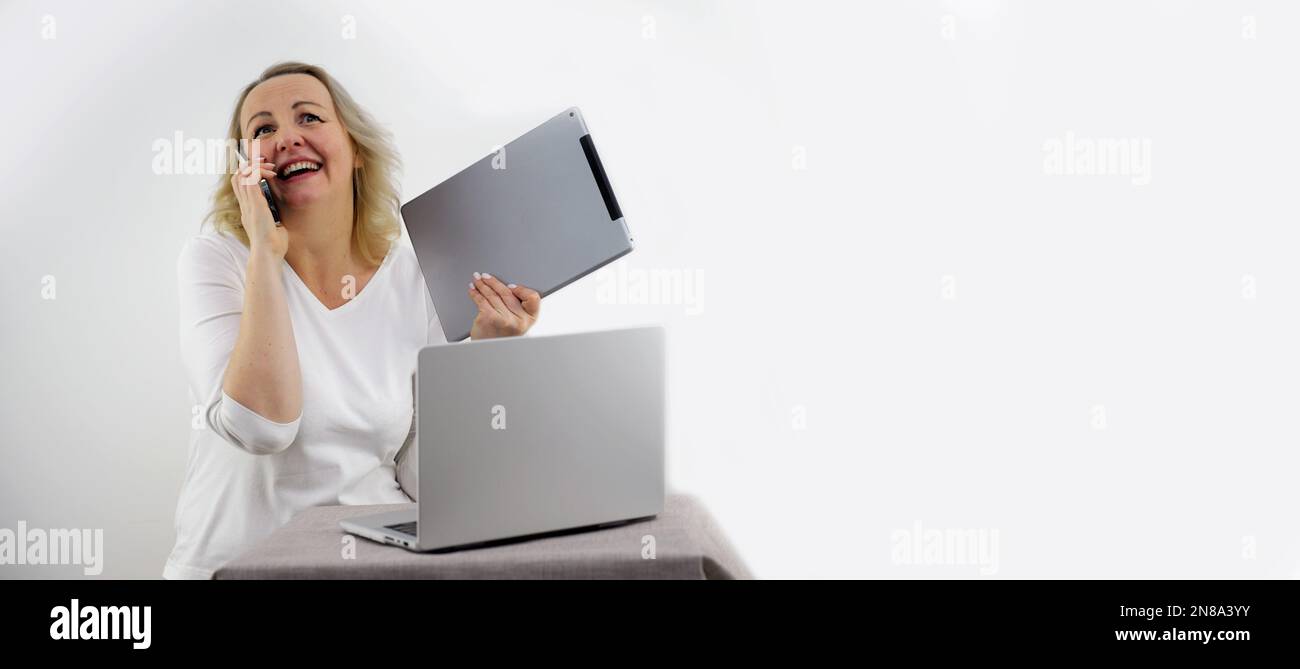 banner per gadget spazio per testo donna con tablet e telefono stand vicino a laptop chiamate dice ridere pleases sincero sorriso comprare ultima tecnologia sviluppo online formazione vendita pubblicità Foto Stock