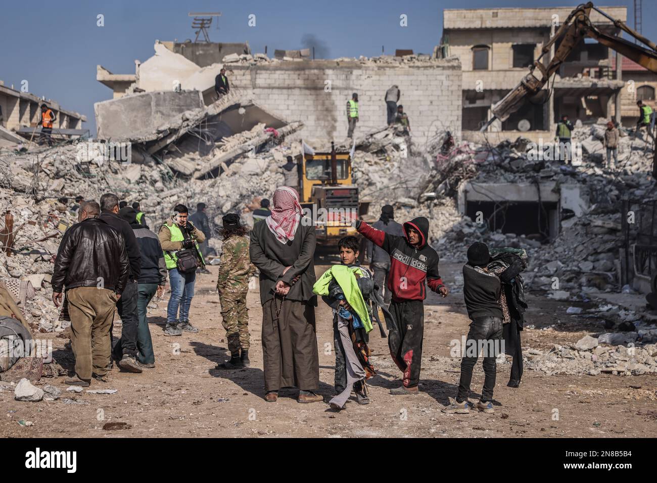 Jindires, Siria. 11th Feb, 2023. La gente si trova accanto a un edificio distrutto durante le operazioni di recupero a seguito del letale terremoto che ha colpito Turchia e Siria. Credit: ANAS Alkharboutli/dpa/Alamy Live News Foto Stock