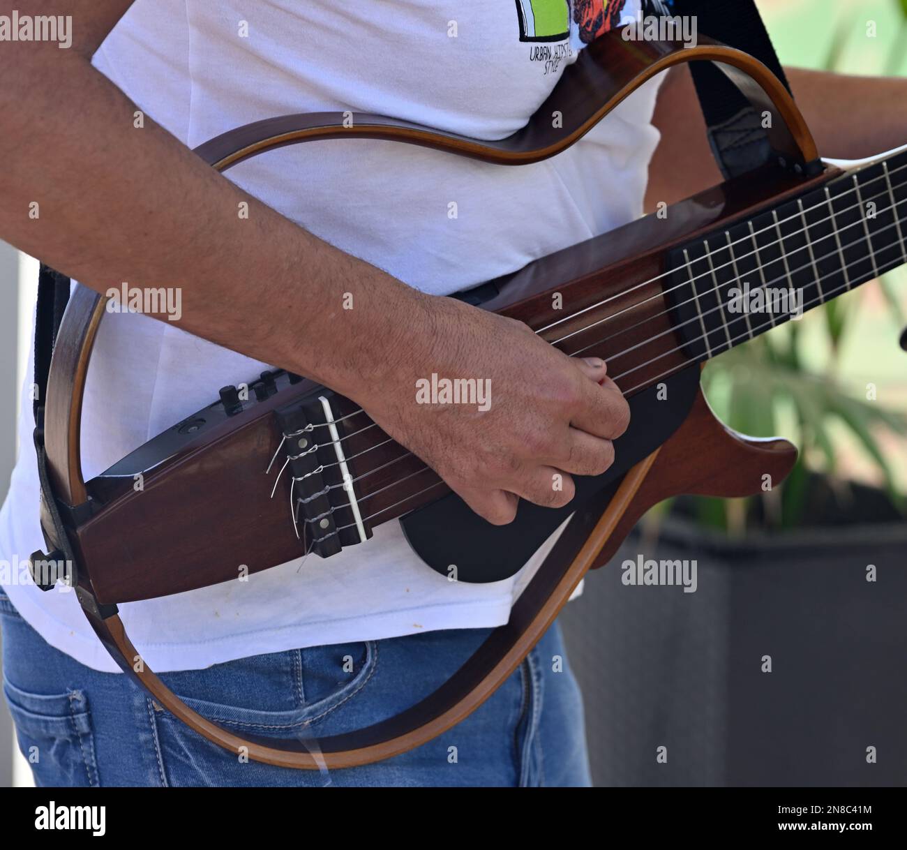 L'uomo (El Tiko Frometa) suona una chitarra elettrica per violino rock a 6 corde con cornice aperta all'esterno Foto Stock