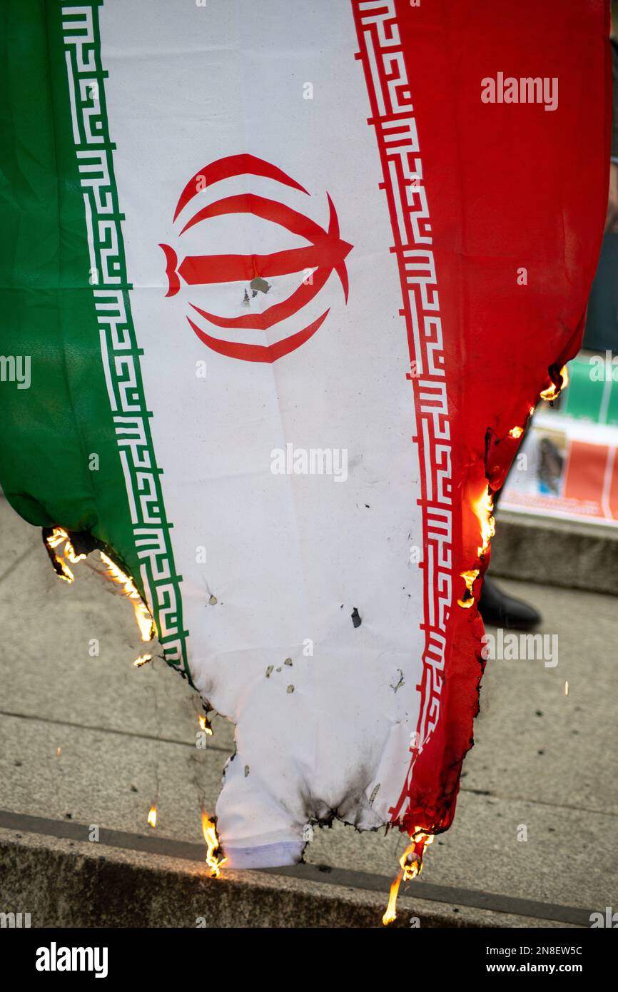 Londra, Regno Unito - 11 febbraio 2023: Manifestanti che bruciano la bandiera della Repubblica islamica dell'Iran come oggi segna il 44th° anniversario della Rivoluzione islamica in Iran. Oggi, dopo più di cinque mesi di continua protesta a sostegno della donna, della vita, del movimento per la libertà, migliaia di manifestanti si sono riuniti a Trafalgar Sq. Denunciare il regime in Iran. I manifestanti tenevano bandiera Shir-o-Khorshid (Leone e Sole) dell'Iran, la bandiera, o il suo emblema, facevano parte dell'identità nazionale iraniana per secoli, che fu cambiata dopo la Rivoluzione islamica del 1979. Credit: Sinai Noor/Alamy Live News Foto Stock
