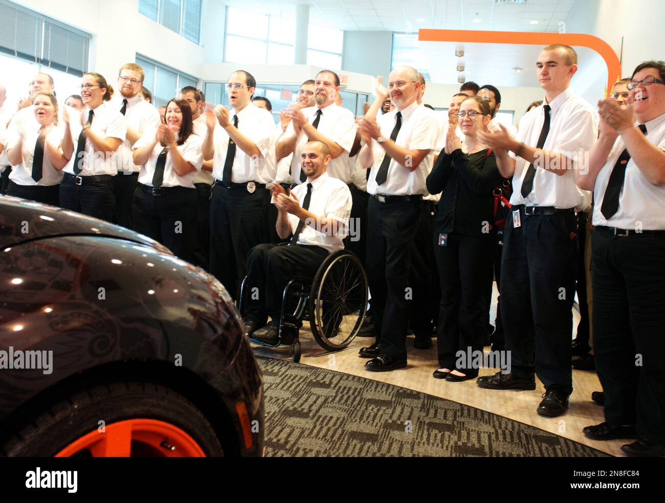 Geek Squad Agents cheer the arrival of a "tricked-out" Geekmobile from West Coast Customs at Geek Squad City Friday, Dec. 7, 2012 in Louisville, Ky. (Photo by Joe Imel/Invision for Best Buy/AP Images) Foto Stock