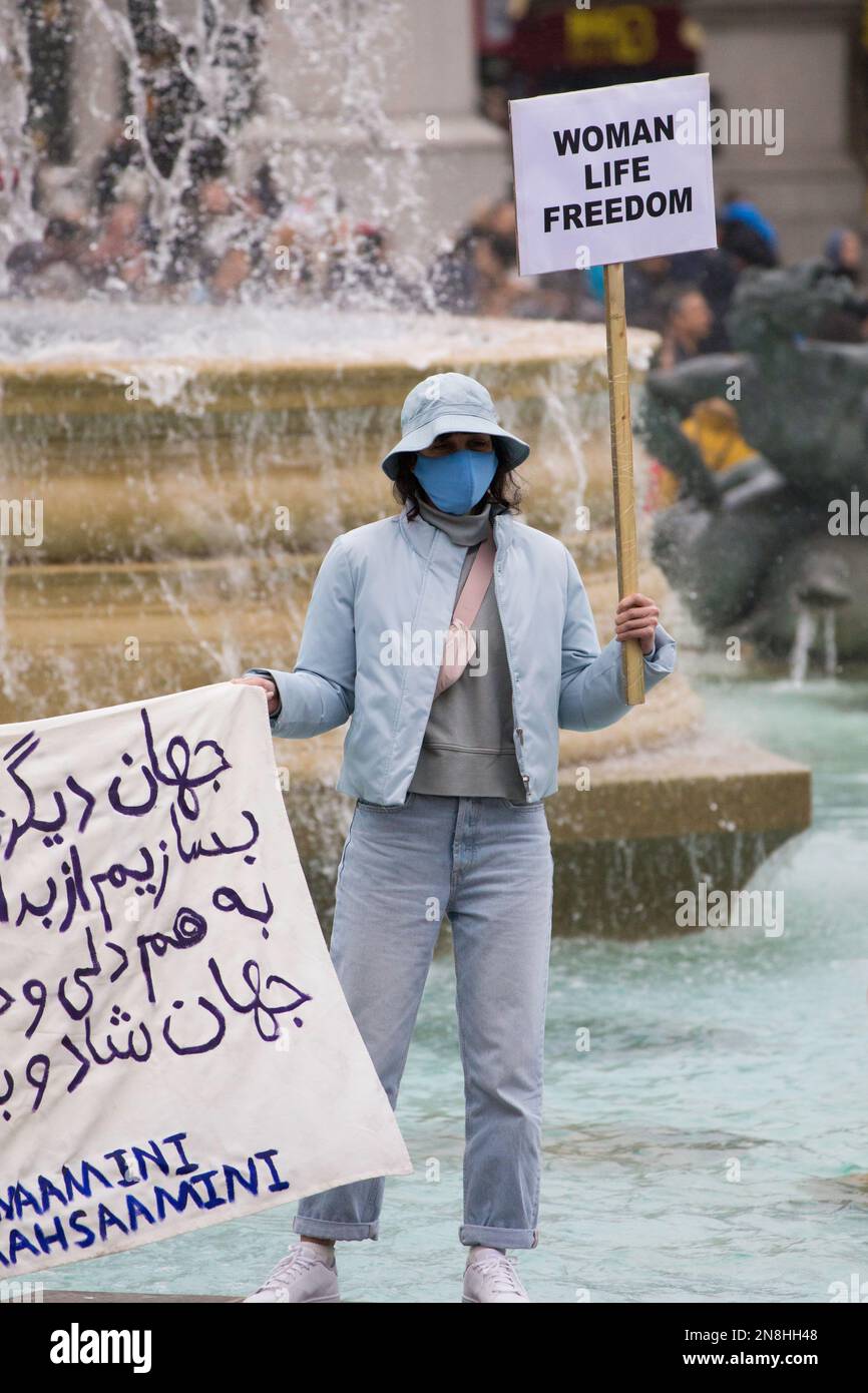 Donna con bandiera alla Woman Life Freedom protesta a Trafalgar Square Foto Stock