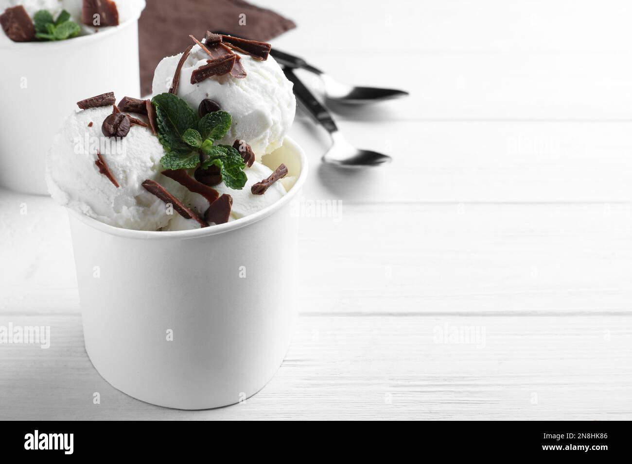 Gelato squisito con cioccolato servito su un tavolo di legno bianco. Spazio per il testo Foto Stock