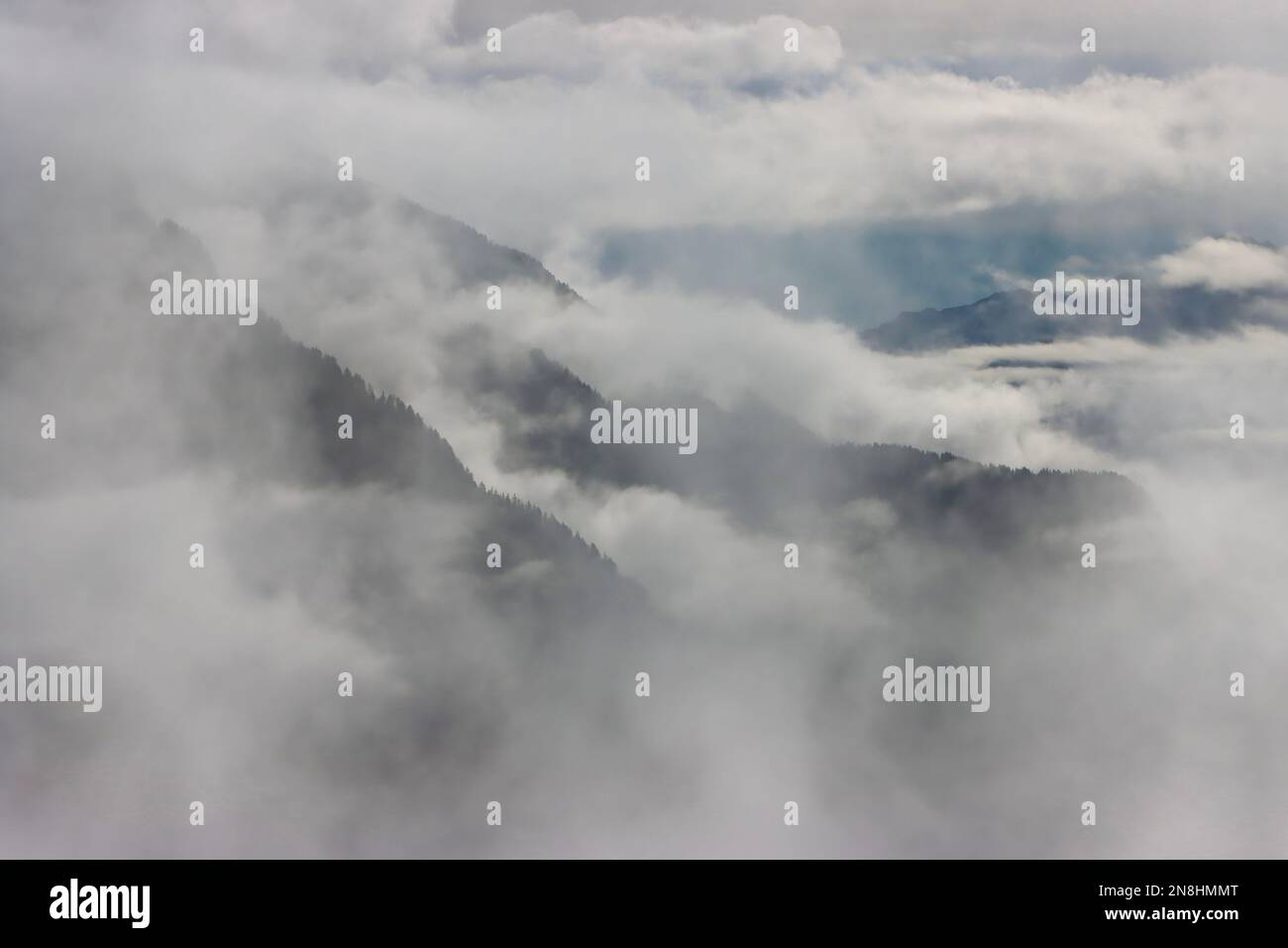 Le catene montuose delle Alpi viste attraverso le nuvole e la nebbia nel gennaio 2023 Foto Stock
