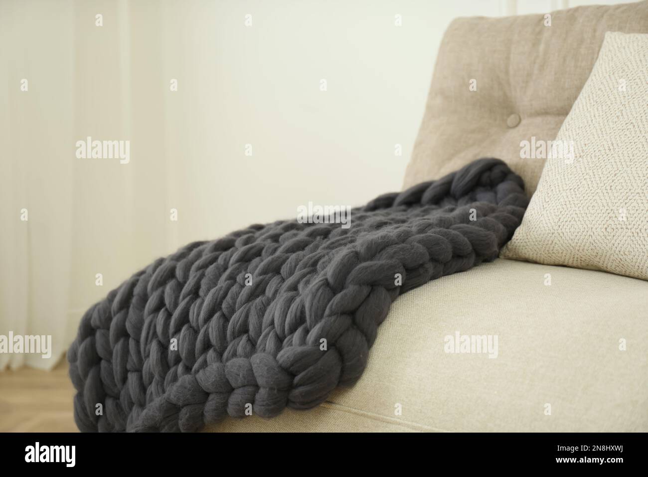 Plaid in lana merino lavorato a maglia sul divano in camera Foto stock -  Alamy