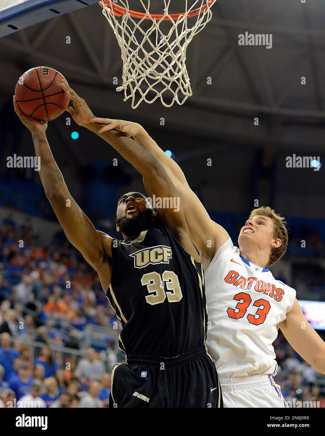 Central Florida forward Keith Clanton (33) stretches to get the ball up to the basket as Florida forward/center Erik Murphy (33) defends during the second half of an NCAA college basketball game, Friday, Nov. 23, 2012, in Gainesville, Fla. Florida won 79-66. (AP Photo/Phil Sandlin) Foto Stock