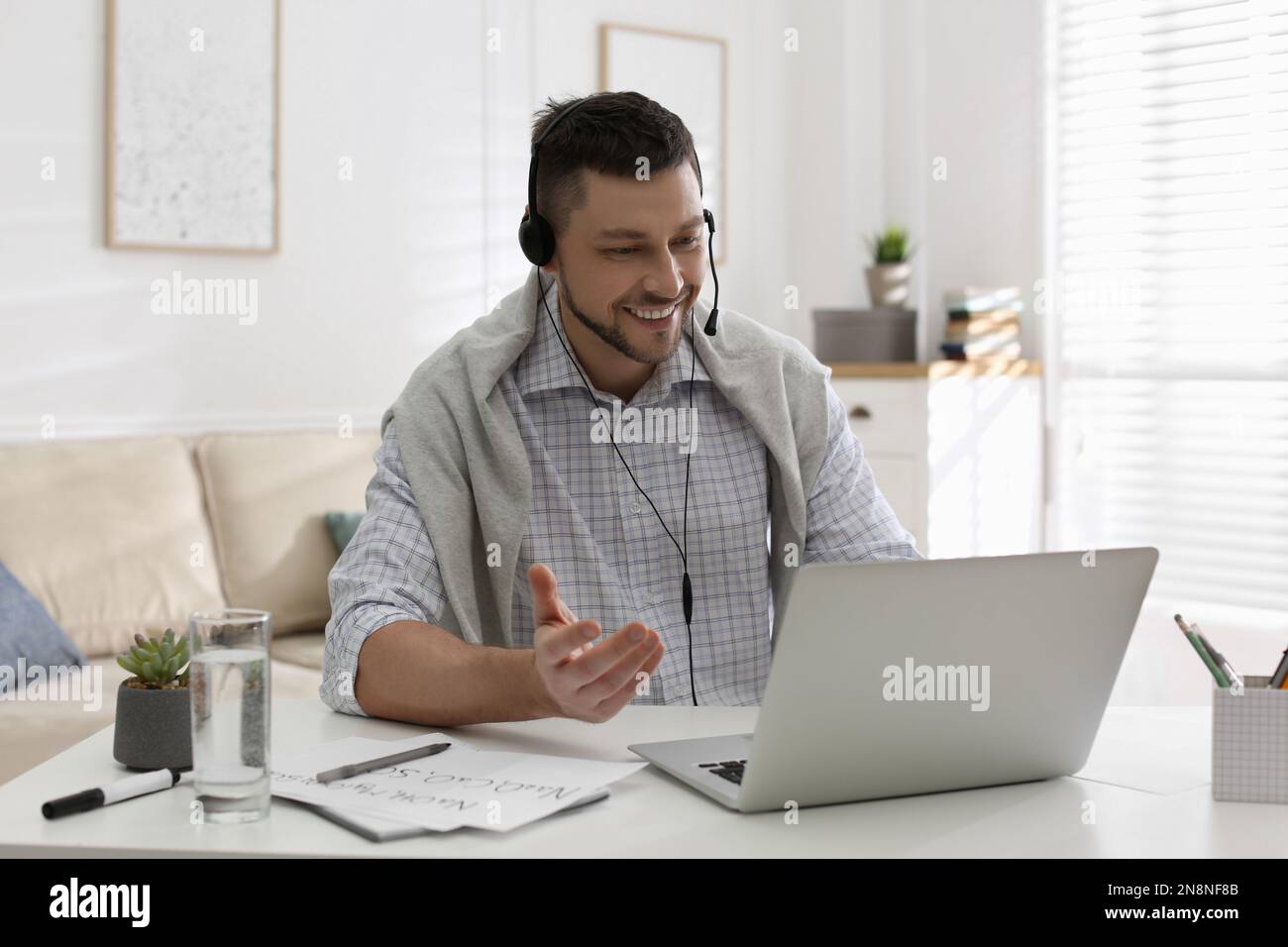 Insegnante che conduce una lezione online a casa durante la quarantena COVID-19 Foto Stock