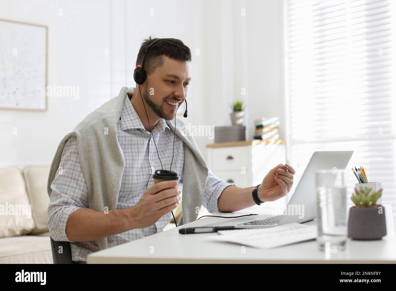 Insegnante che conduce una lezione online a casa durante la quarantena COVID-19 Foto Stock