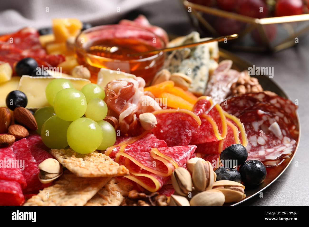 Piatto di antipasti diversi con miele sul tavolo, primo piano Foto Stock
