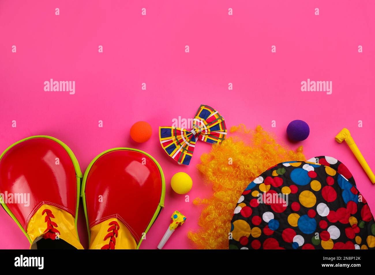 Composizione a posa piatta con accessori di clown su sfondo rosa