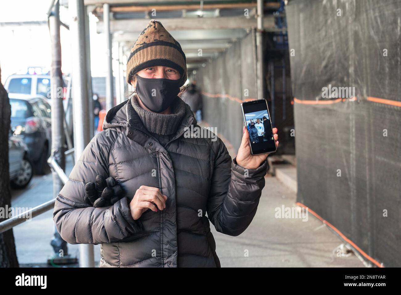 New York, Stati Uniti. 11th Feb, 2023. Il richiedente asilo si mostra orgogliosamente selfie con il sindaco Eric Adams che ha contribuito a distribuire cibo e abbigliamento alla scuola pubblica 20 a New York il 11 febbraio 2023. Ai migranti venivano offerti pasti caldi e potevano scegliere tra abiti donati. Ai migranti è stato inoltre offerto di sottoscrivere un'assicurazione medica gratuita fornita dalla città - MetroPlusHealth. Al Sindaco si è aggiunto il Commissario per gli Affari sull'immigrazione Manuel Castro. L'evento è stato organizzato da Aid for Life International e dai loro volontari. (Foto di Lev Radin/Sipa USA) Credit: Sipa USA/Alamy Live News Foto Stock