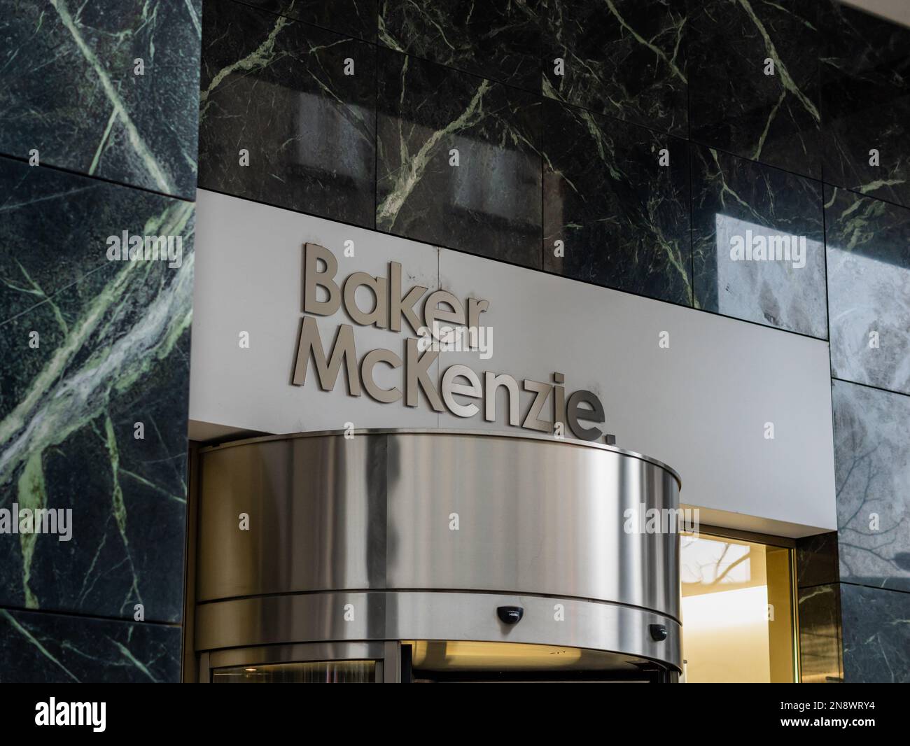 Baker McKenzie segno sopra l'entrata di un edificio di uffici. Studio legale tedesco con esperienza nel lavoro transfrontaliero e nella pratica fiscale. Foto Stock