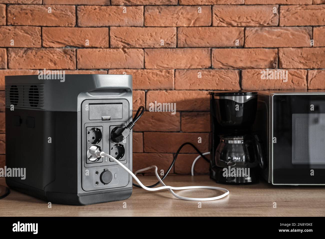 Macchina per il caffè e forno a microonde collegati alla stazione di  alimentazione portatile sul banco della cucina Foto stock - Alamy