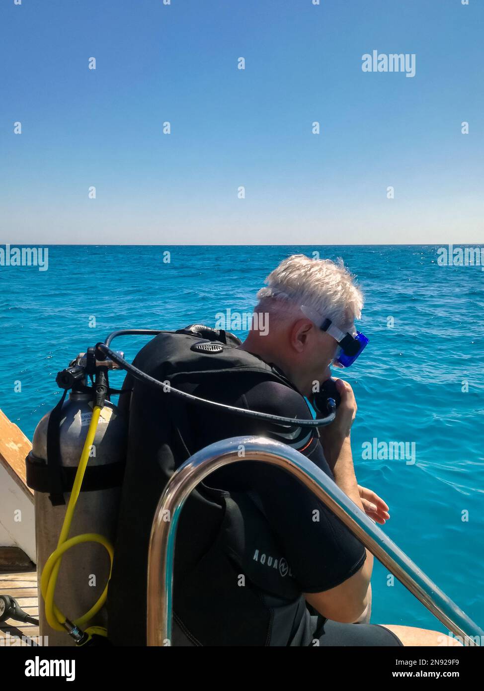 Tuffatore che si prepara per l'immersione. Lezione di immersione in mare aperto. L'uomo con le immersioni si tufferà in mare profondo. Hurghada, Egitto - Ottobre 2022 Foto Stock