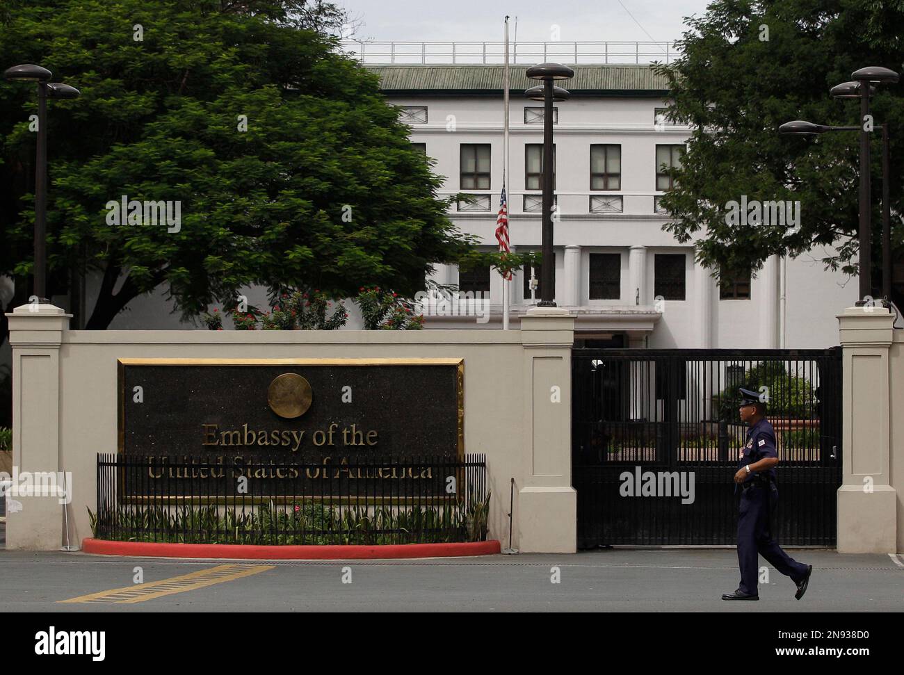 A security guard walks in front of the U.S. Embassy in Manila, Philippines, Thursday, Sept. 13, 2012 as it's flag is on half mast following the death of US diplomats in Libya. Manila police tightened security in the area following the attack that killed the U.S. envoy and other diplomats in Libya. (AP Photo/Aaron Favila) Foto Stock