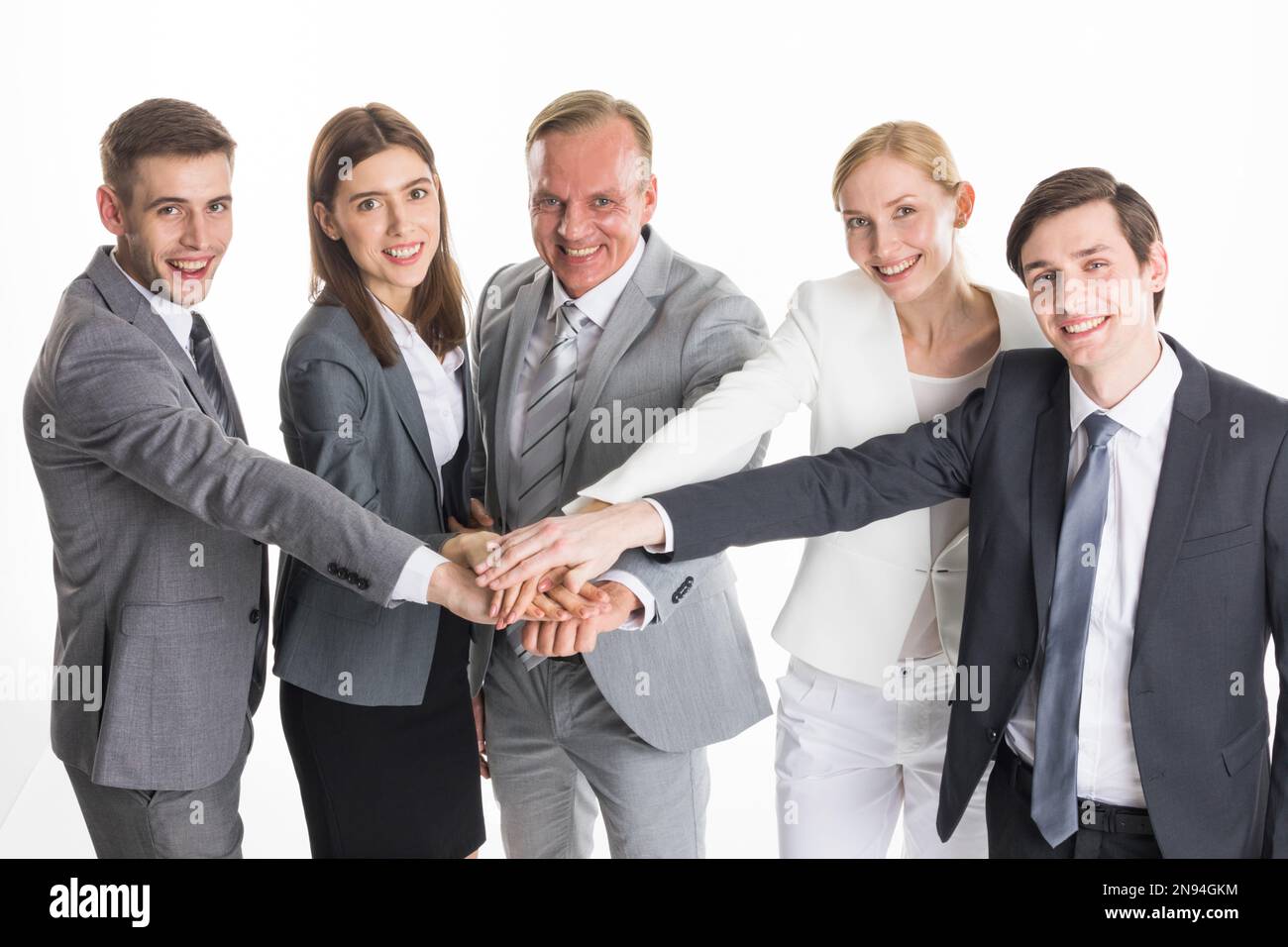 Uomini d'affari colleghi impilando la mano per collaborare, studio isolato su sfondo bianco Foto Stock