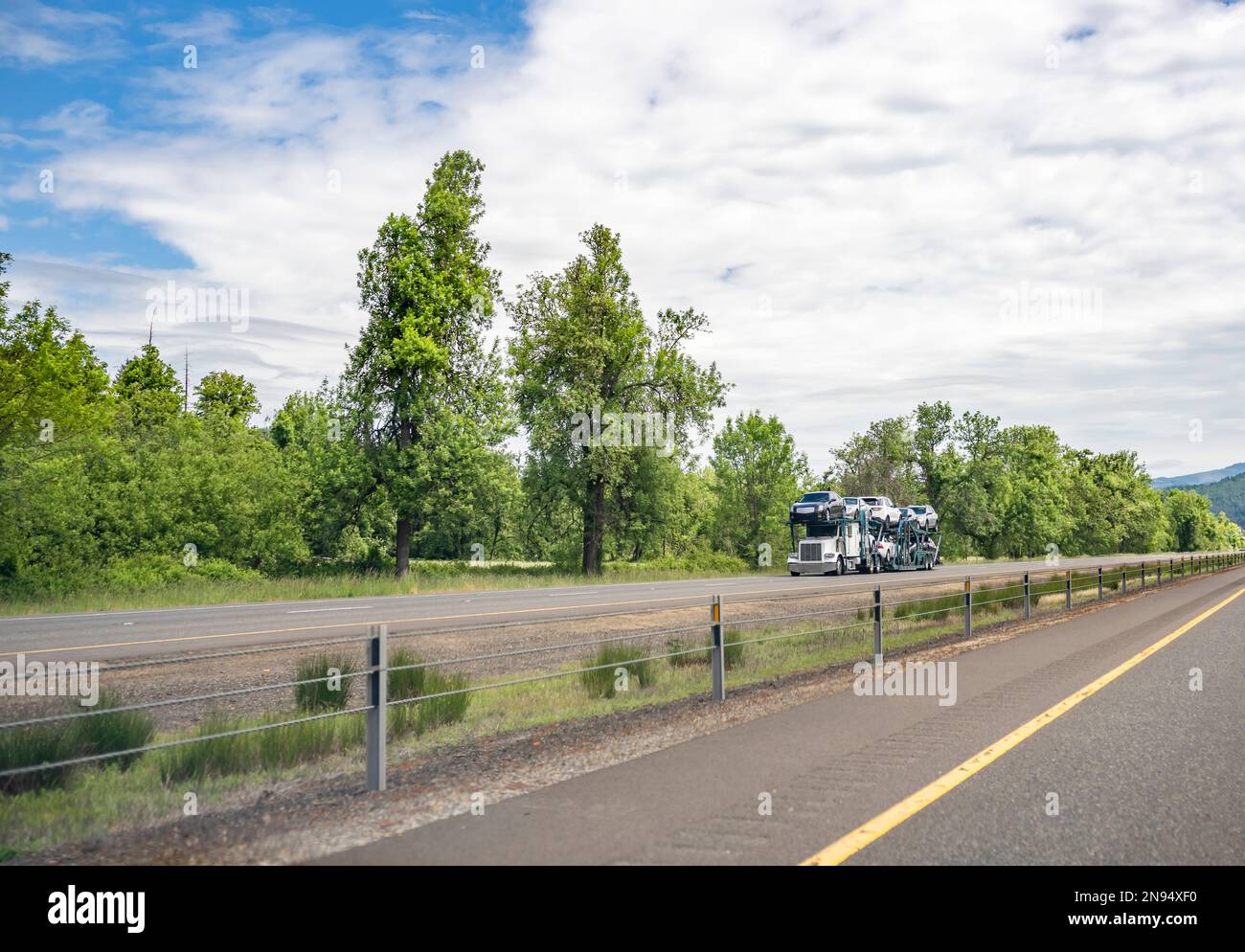Semirimorchio bianco per trasporto di vetture a carro grande di qualità industriale classico per trasporto di vetture sul semirimorchio idraulico modulare che guida sul Hi diviso Foto Stock