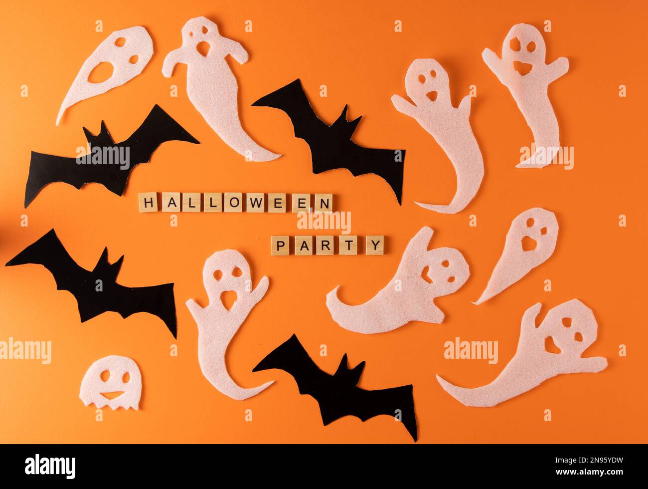Fantasmi bianchi e mazza per la festa di Halloween. Immagine fantasma della carta di avvolgimento su sfondo arancione vista dall'alto. Fumetto Creepy Whisper. Fai-da-te fatto a mano. Impostare i caratteri boo. Parola frase di legno della lettera. Foto Stock