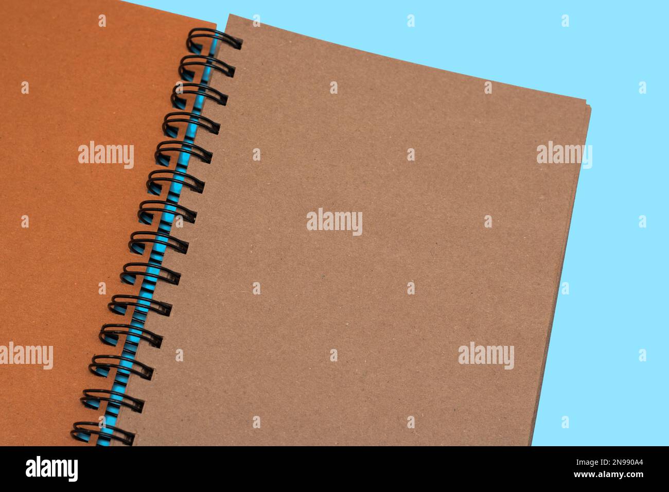 Notebook, con spazio per i dettagli di immagine, testo o identità aziendale. Vuoto con ombra su sfondo blu. Blocco note a spirale su un tavolo. Giacitura piatta, da a. Foto Stock
