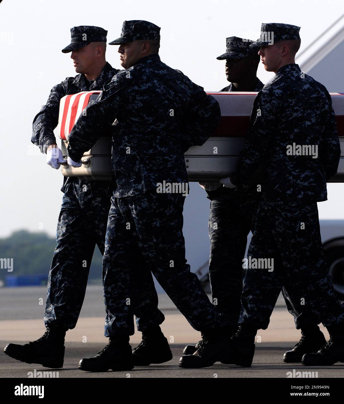 A Navy carry team moves a transfer case containing the remains of Petty Officer 3rd Class Clayton R. Beauchamp Thursday, Aug. 9, 2012 at Dover Air Force Base, Del. According to the Department of Defense, Beauchamp, of Weatherford, Texas, died Aug. 7, 2012 when enemy forces attacked his united with an improvised explosive device in Helmand province, Afghanistan. (AP Photo/Steve Ruark) Foto Stock