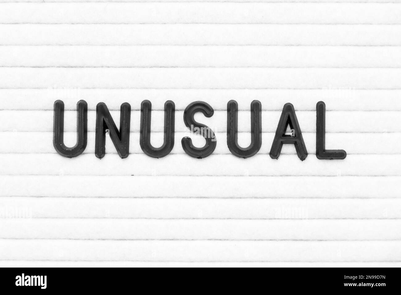 Lettera di colore nero in parola insolito su sfondo bianco cartone feltro Foto Stock