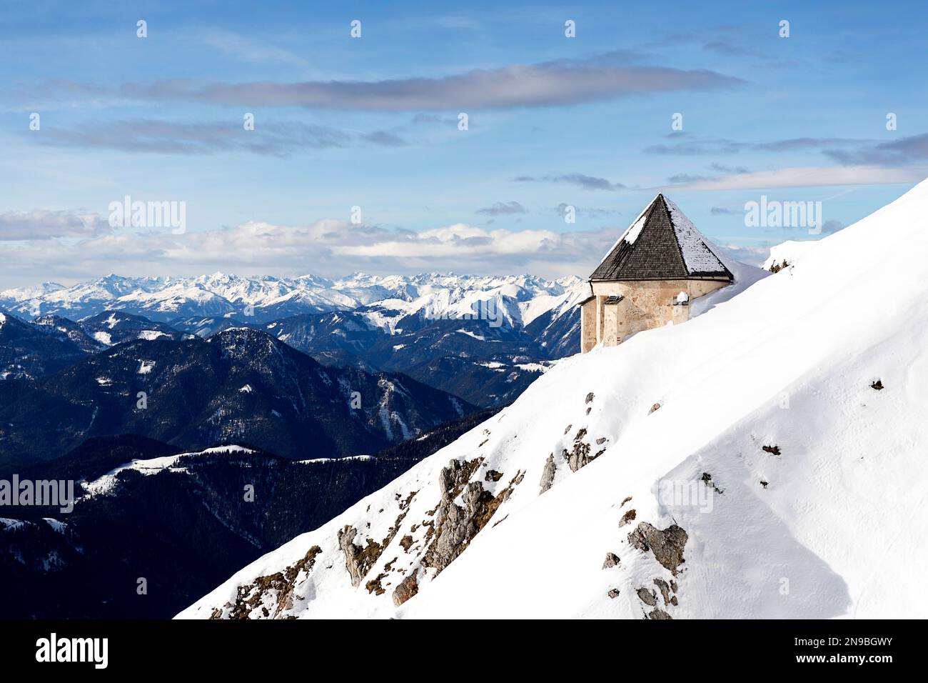 Windische Kirche, una chiesa di Windische su una montagna innevata Dobratsch in perfette condizioni invernali soleggiate, Villach, Austria Foto Stock